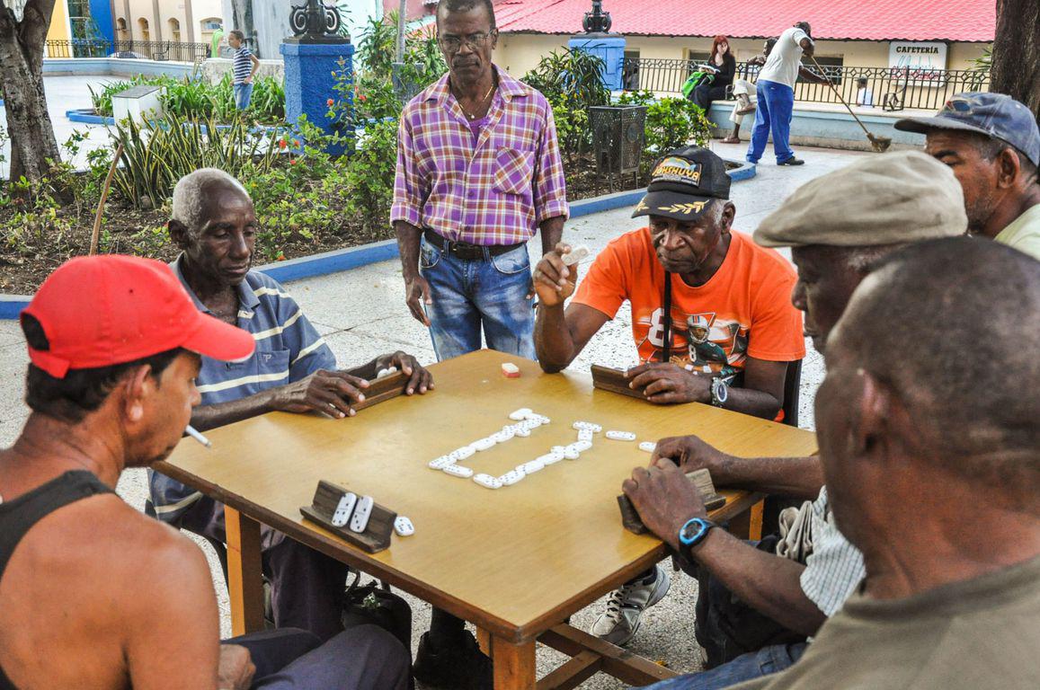 Des hommes en train de jouer aux dominos dans un parc à Cuba
