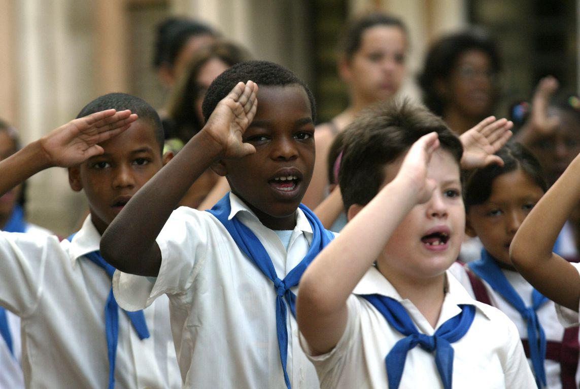Des Pioneros, élèves de l'école primaire cubaine, qui chantent l'hymne national