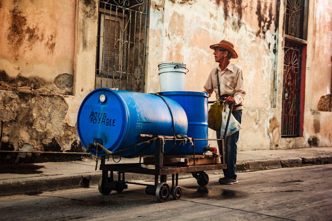 Un homme transporte un bidon d'eau dans les rues de Gibara, village à l'est de Cuba