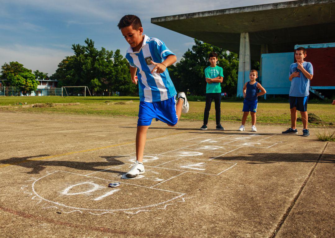 Des enfants cubains jouent à la marelle, dit